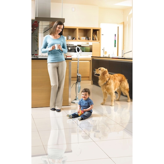 BLACKDECKER FSM1630 steam mop in kitchen setting with woman, child, and dog on clean tiles.
