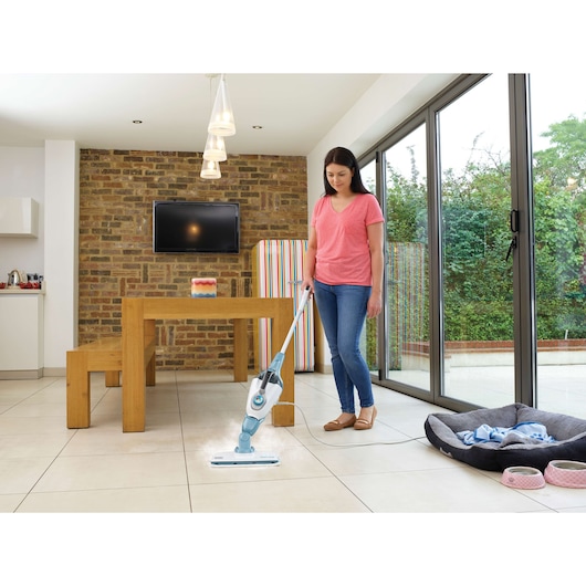 BLACKDECKER FSMH1321 steam mop cleaning tile floor in modern kitchen, shown with mop emitting steam.
