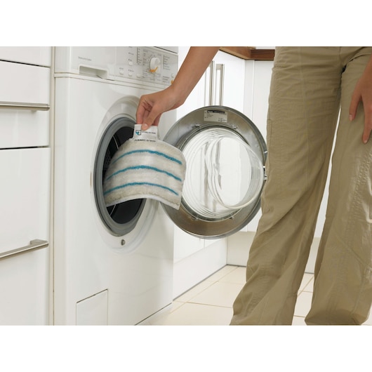 BLACKDECKER FSMP20 white microfiber pad with blue stripes being placed in washing machine