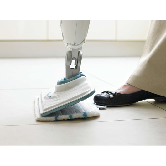 BLACKDECKER FSMP20 steam mop pad being attached to mop head on tiled floor, side angle.