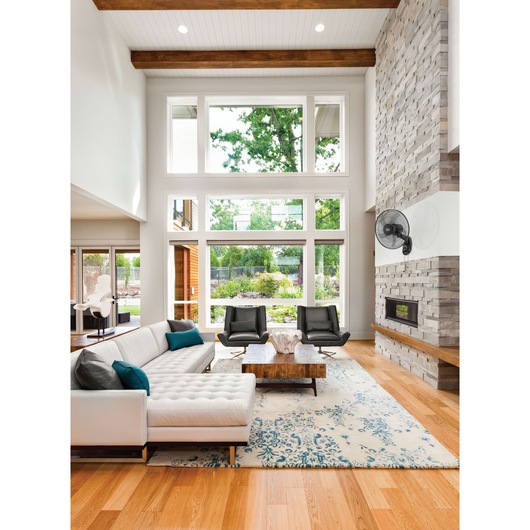 BLACKDECKER FW1620 black oscillating wall fan mounted in modern living room, left side view.