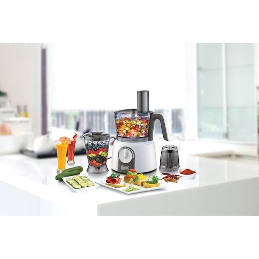 BLACKDECKER FX1075 food processor with attachments, filled with vegetables, on a kitchen counter.