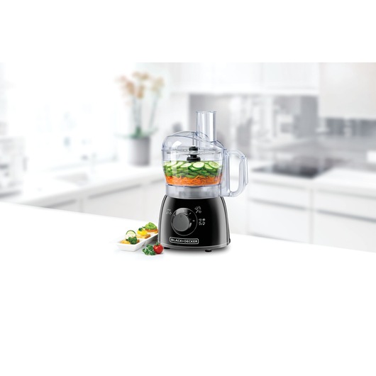 BLACKDECKER FX400 food processor in black on kitchen counter with sliced vegetables in bowl.