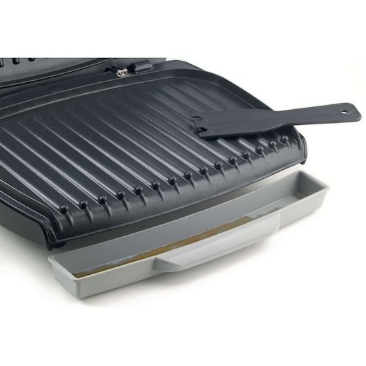 BLACKDECKER GM1750 electric grill with open non-stick plates, cleaning tool and grey drip tray, front angle.