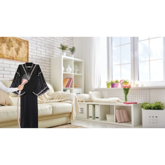 BLACKDECKER GSTD2050 handheld garment steamer used on black dress in modern living room setting
