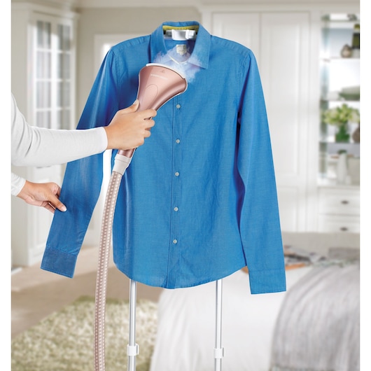 BLACKDECKER GSTD2050 garment steamer in use on blue dress shirt, handheld close-up, home setting.