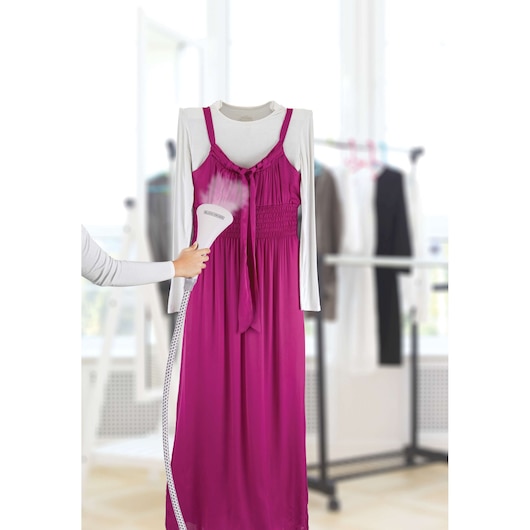 BLACKDECKER GSTM2050 handheld garment steamer in use on a magenta dress and white shirt indoors.