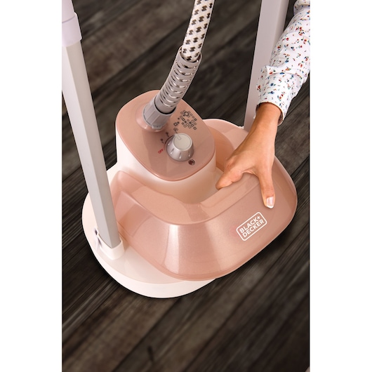 BLACK+DECKER GSTM2050 garment steamer base in rose color with control knob, photographed from above.