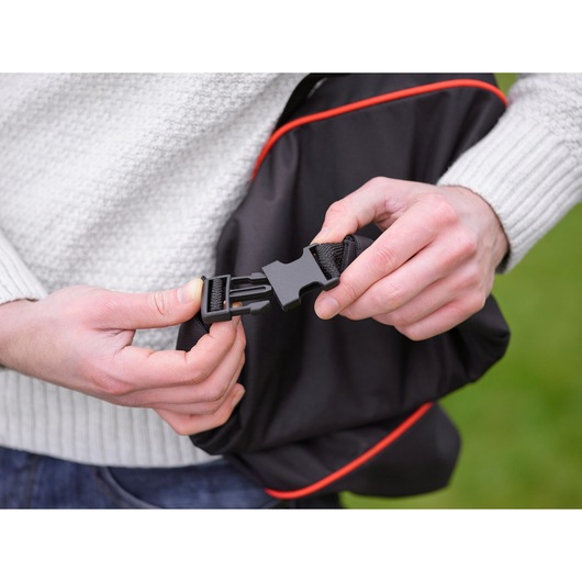 BLACKDECKER GW3031BP black bag strap buckle with red trim being fastened outdoors, close-up.