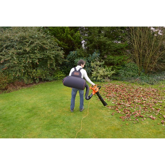 Photo of BLACKDECKER GW3031BP leaf blower and vacuum with backpack in use on a grassy lawn.