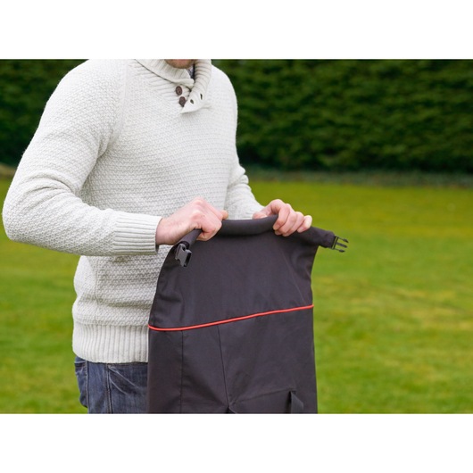 Photo of BLACKDECKER GW3031BP lawn vacuum bag with red trim, held outdoors by a person in a white sweater.