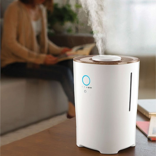 BLACKDECKER HM4000 humidifier with brown top emitting mist, shown on table in living room.