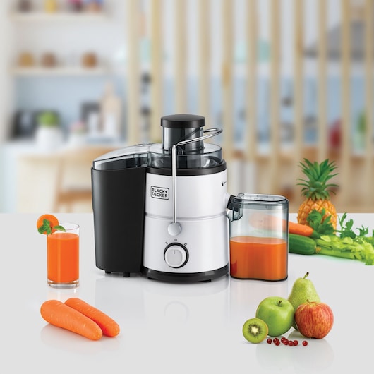 Photo of BLACK+DECKER JE600 juicer on countertop with fresh juice, carrots, apple, pear, kiwi, and pineapple.