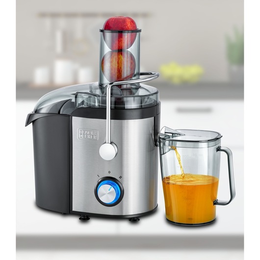 BLACKDECKER JE800 stainless steel juicer front view with apples in feed chute and juice pouring into clear pitcher.