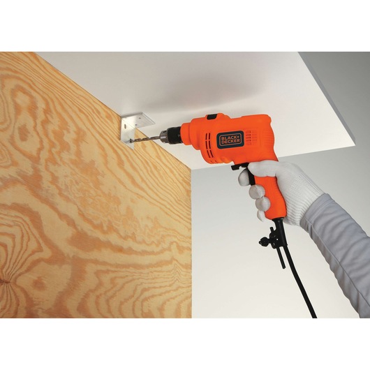 BLACKDECKER KR5010V orange corded drill used for drilling metal bracket onto wood panel.
