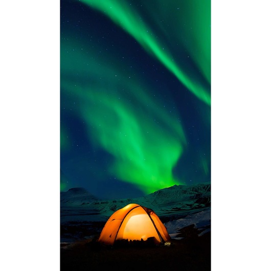 BLACKDECKER LE3 photography of glowing orange tent under green aurora lights in snowy landscape at night.