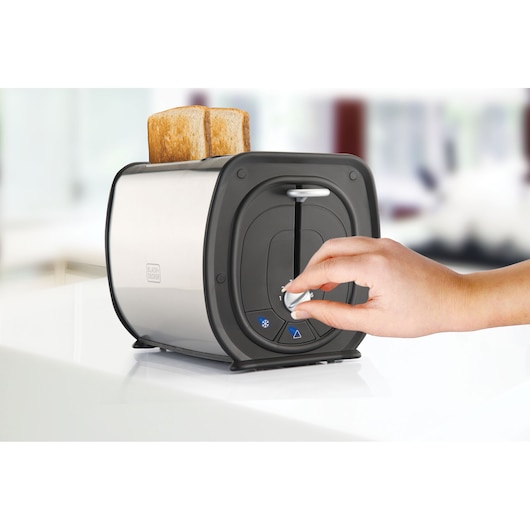 BLACKDECKER MBF50 toaster with two slices of bread, hand adjusting dial, side view on counter.