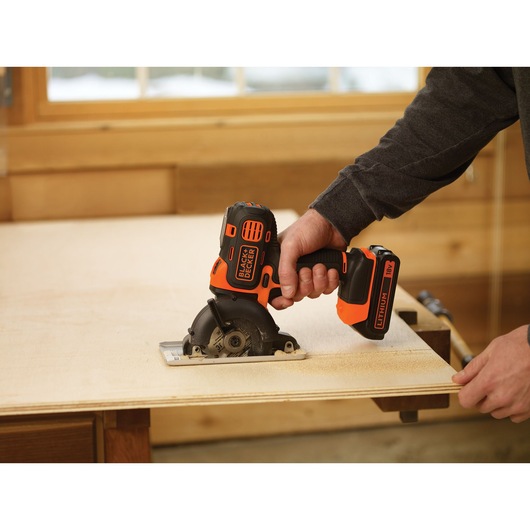 BLACKDECKER MT218K cordless mini circular saw cutting plywood, handheld in workshop.