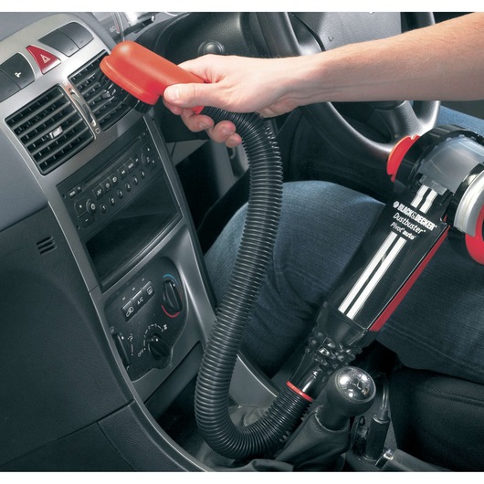 BLACK+DECKER PAV1205 handheld car vacuum cleaner in use with flexible hose cleaning air vents.