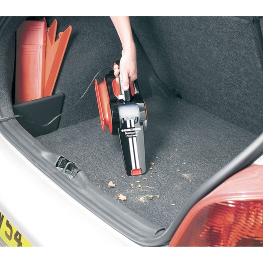 BLACKDECKER PAV1205 handheld car vacuum cleaning car trunk, black and red design, angled view.