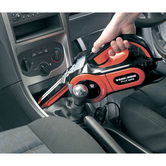 BLACKDECKER PAV1205 handheld car vacuum cleaner in use inside vehicle interior.