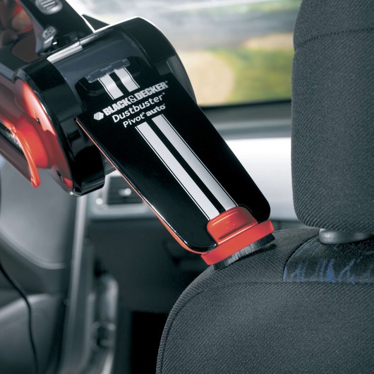 BLACK+DECKER PAV1205 handheld car vacuum cleaning car seat upholstery, close-up view of nozzle with brush.