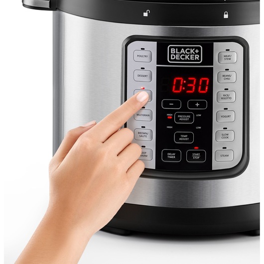 Close-up of a hand pressing the dessert button on a BLACK+DECKER PCP1000 multicooker control panel, front angle.