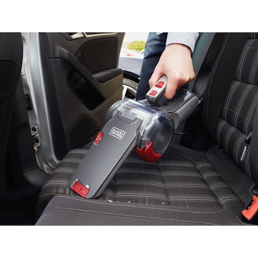 Photo of BLACK+DECKER PV1200AV handheld vacuum cleaning a car seat, with a closeup of the vacuum in use.