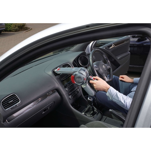 BLACK+DECKER PV1200AV handheld vacuum cleaner used to clean car dashboard interior, side angle.