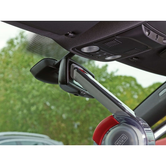 BLACK+DECKER PV1200AV handheld vacuum cleaning a car interior near the rearview mirror.