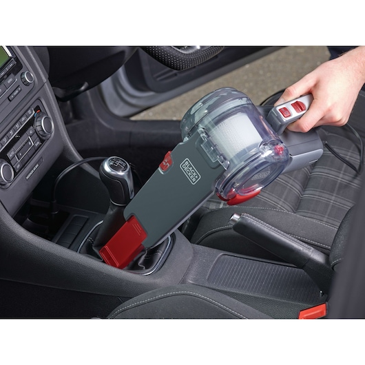 BLACK+DECKER PV1200AV handheld car vacuum cleaner with red and gray design used to clean car interior.
