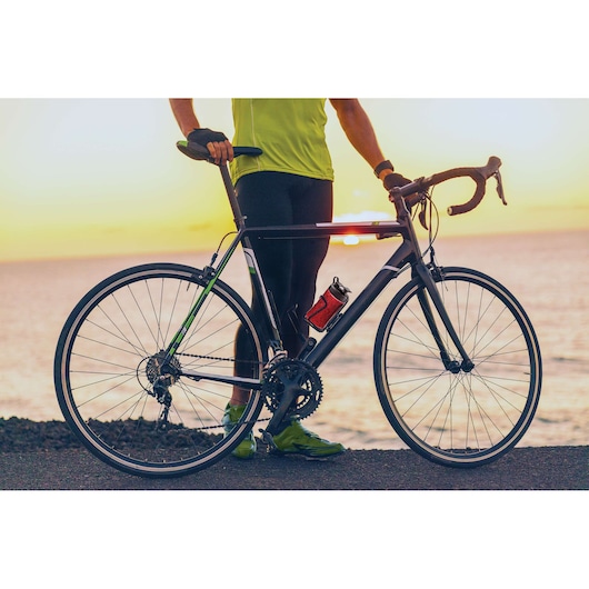 BLACKDECKER SBX300 road bike with water bottle, side view, photographed at sunset by the sea.