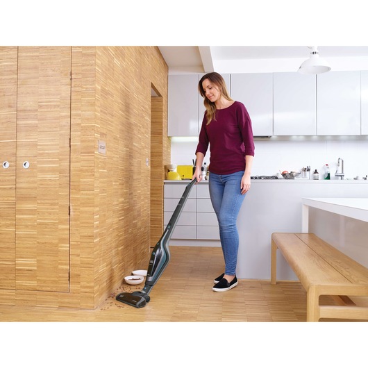 BLACKDECKER SVA420B cordless stick vacuum cleaning kitchen floor, photography of modern interior.