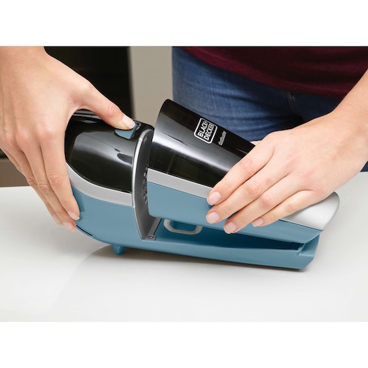 BLACKDECKER SVA420B handheld vacuum photography, close-up showing blue and black device being removed from base.