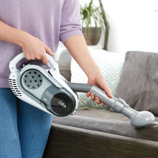 BLACK+DECKER SVFV3250L handheld vacuum cleaner with flexible hose cleaning a sofa.