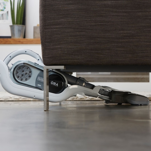 BLACKDECKER SVFV3250L stick vacuum cleaning under a sofa in a living room setting