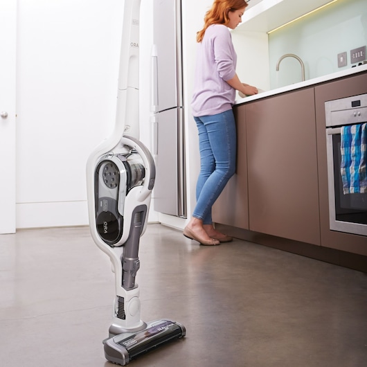 Photo of BLACKDECKER SVFV3250L cordless stick vacuum cleaner standing in a modern kitchen setting.