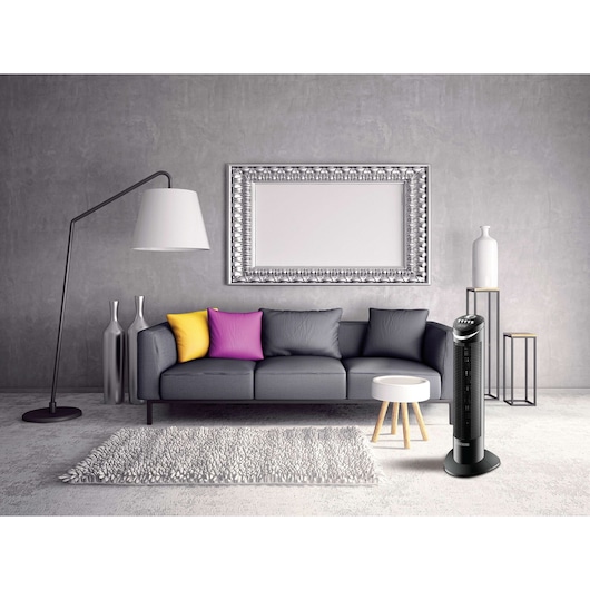 BLACKDECKER TF50 tower fan in modern living room, black color, next to grey sofa and colorful cushions.