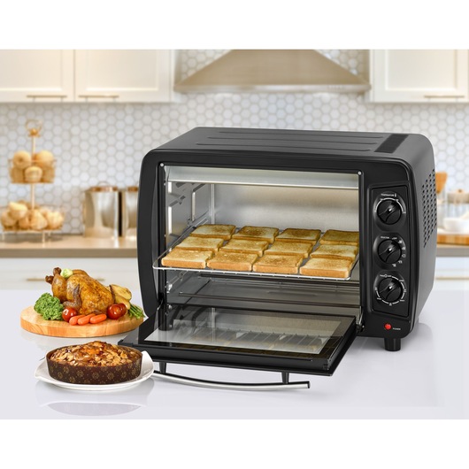 BLACKDECKER TRO35RDG toaster oven with toasted bread, roasted chicken, and cake in a kitchen setting.