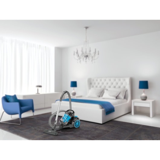 BLACKDECKER VM2080 canister vacuum with blue accents on a bedroom carpet.