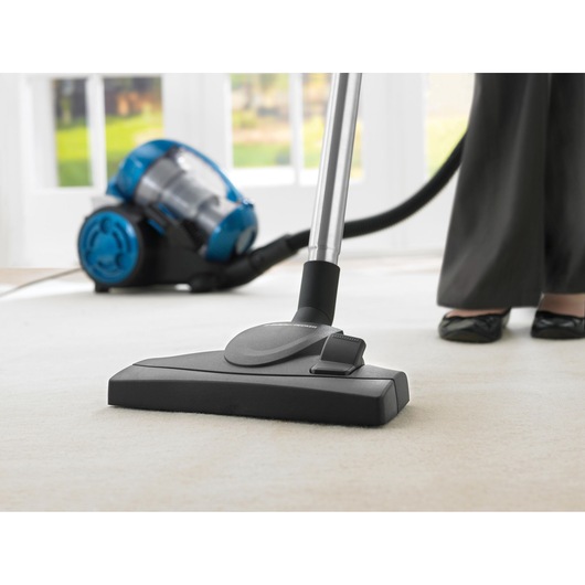 BLACKDECKER VM2825 vacuum cleaner with blue and black canister, shown cleaning a light carpet, front view.
