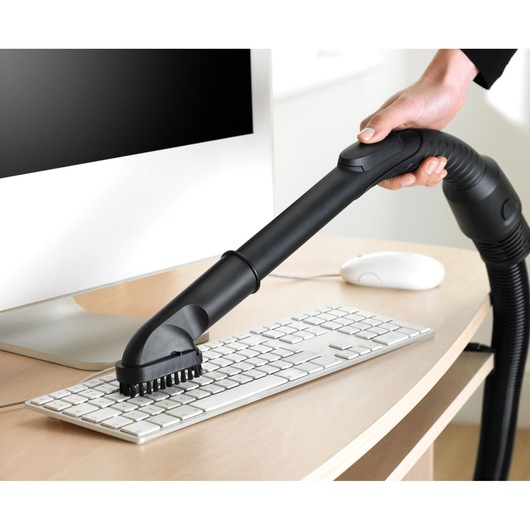 BLACKDECKER VM2825 vacuum cleaner brush attachment cleaning computer keyboard on desk.
