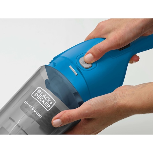 BLACK+DECKER WDB215WA blue handheld vacuum cleaner close-up with hands pressing power button.
