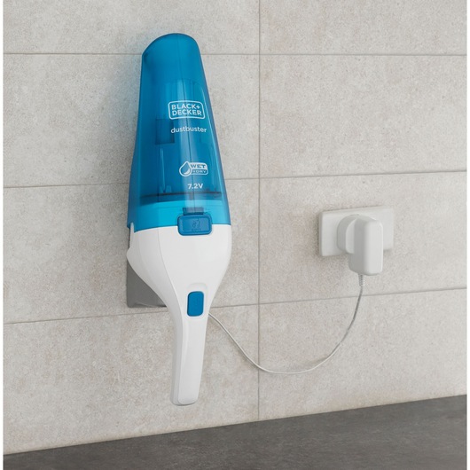 A BLACK+DECKER handheld vacuum cleaner, model WDC115WA, mounted on a wall and connected to a charger. The vacuum has a blue and white design and is labeled for wet and dry use.