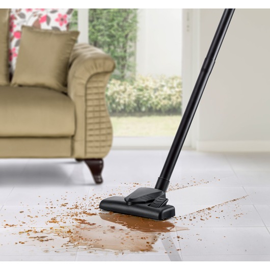 BLACKDECKER WV1450 vacuum cleaner nozzle cleaning spilled liquid and debris on white tile floor, side angle.