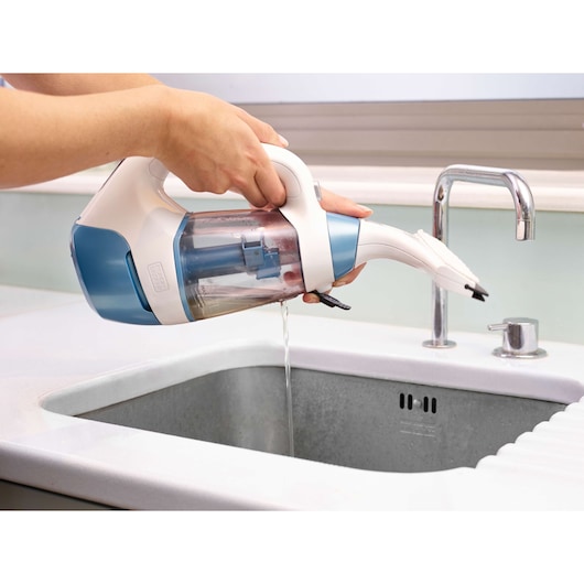 A person is emptying water from a BLACK+DECKER WW100 handheld vacuum cleaner into a sink.
