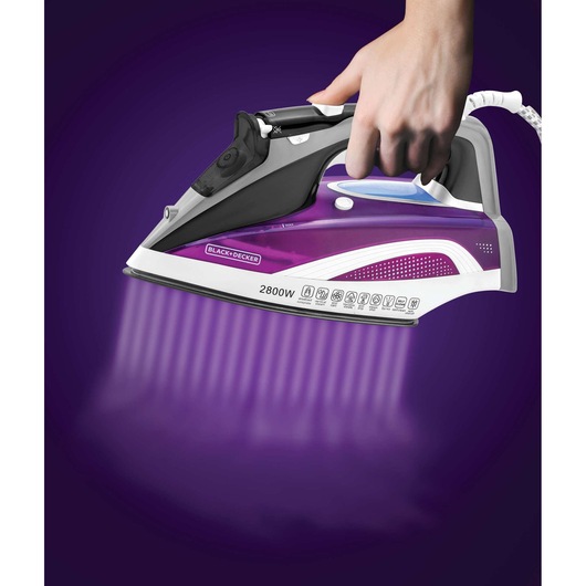 Photo of BLACK+DECKER X2250 steam iron, purple and gray, in use on a purple background.